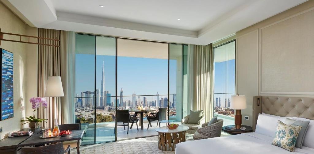 A guest room at Mandarin Oriental Jumeira, Dubai with floor-to-ceiling glass, a private balcony and the Burj Khalifa skyline beyond - the space, materials and position that a 5-star rate is actually paying for