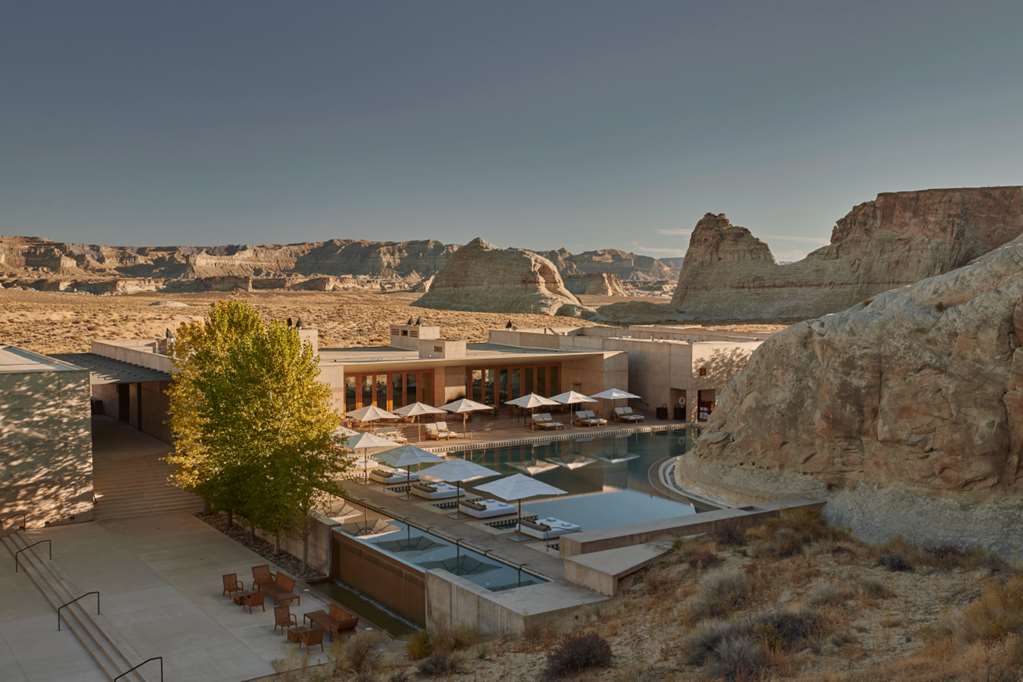 An Amangiri suite with the substantial concrete-and-stone architectural integration with the dramatic sandstone canyon landscape, the dedicated private terrace orientation, and the minimalist contemporary Aman interior identity that defines the property