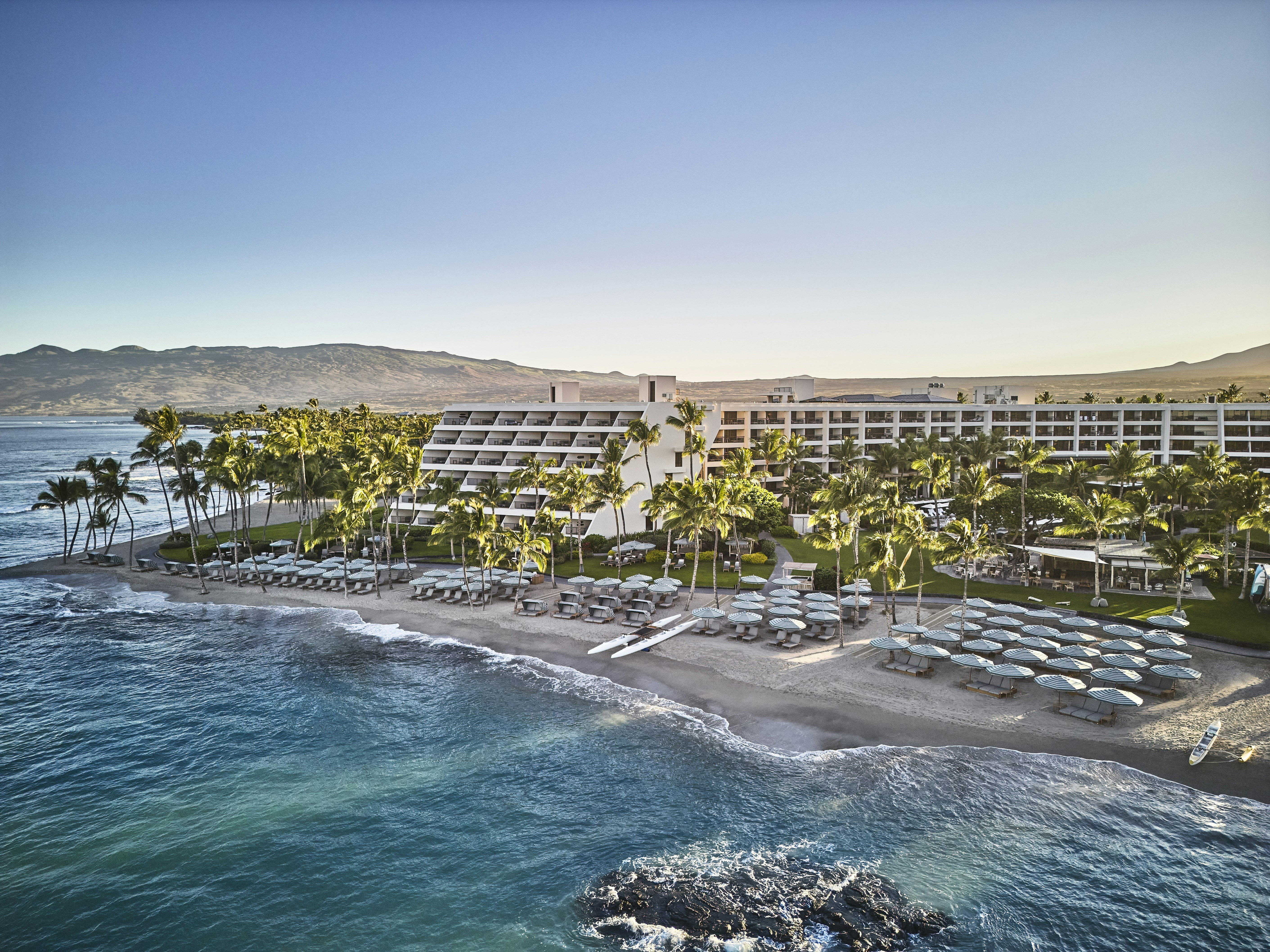 Mauna Lani Auberge Hawaii oceanfront pool deck with the Pacific Ocean and lava rock coastline