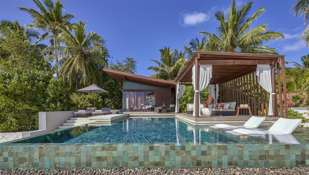 A Park Hyatt Maldives Hadahaa overwater villa with the dedicated direct-lagoon-access configuration and the understated contemporary Park Hyatt interior over the turquoise water