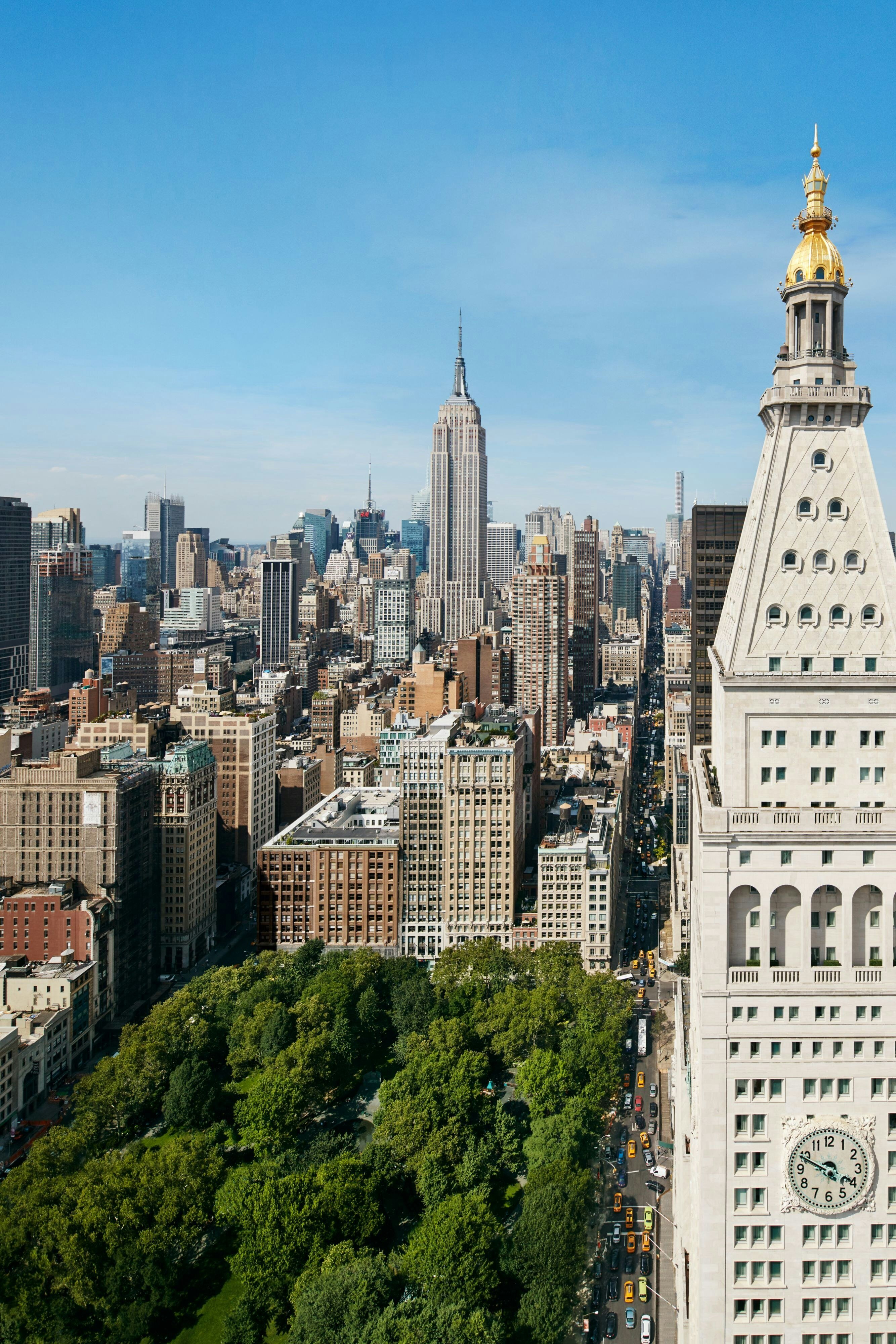 The New York EDITION lobby and lounge with the substantial heritage Beaux-Arts architectural detailing — the heritage clock tower architectural envelope that defines the property's specific Manhattan identity