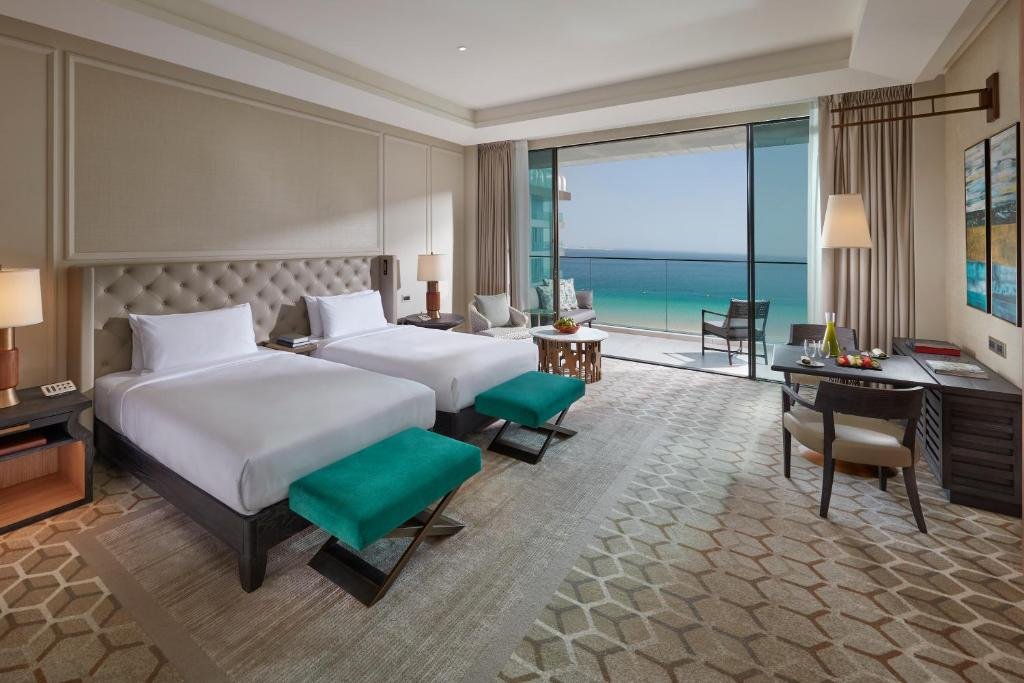 A twin guest room at Mandarin Oriental Jumeira, Dubai with a private balcony over the Arabian Gulf - in Dubai the quoted room rate carries roughly 22 percent in service charge, municipality fee, VAT and Tourism Dirham unless stated as inclusive
