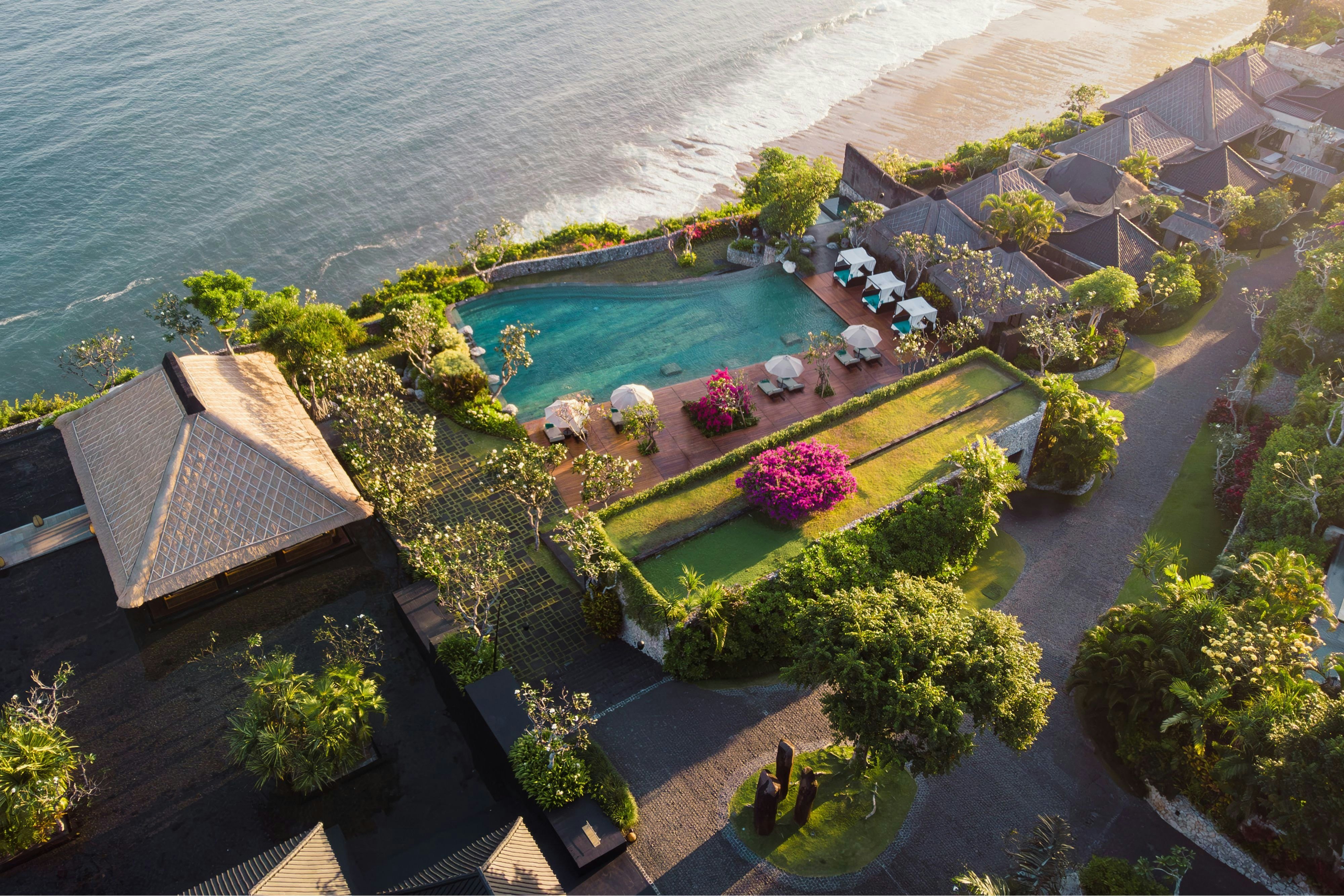 Bvlgari Resort Bali villa interior showing the Italian-Balinese design language with carved volcanic stone, hand-woven textiles, and indoor-outdoor living configuration