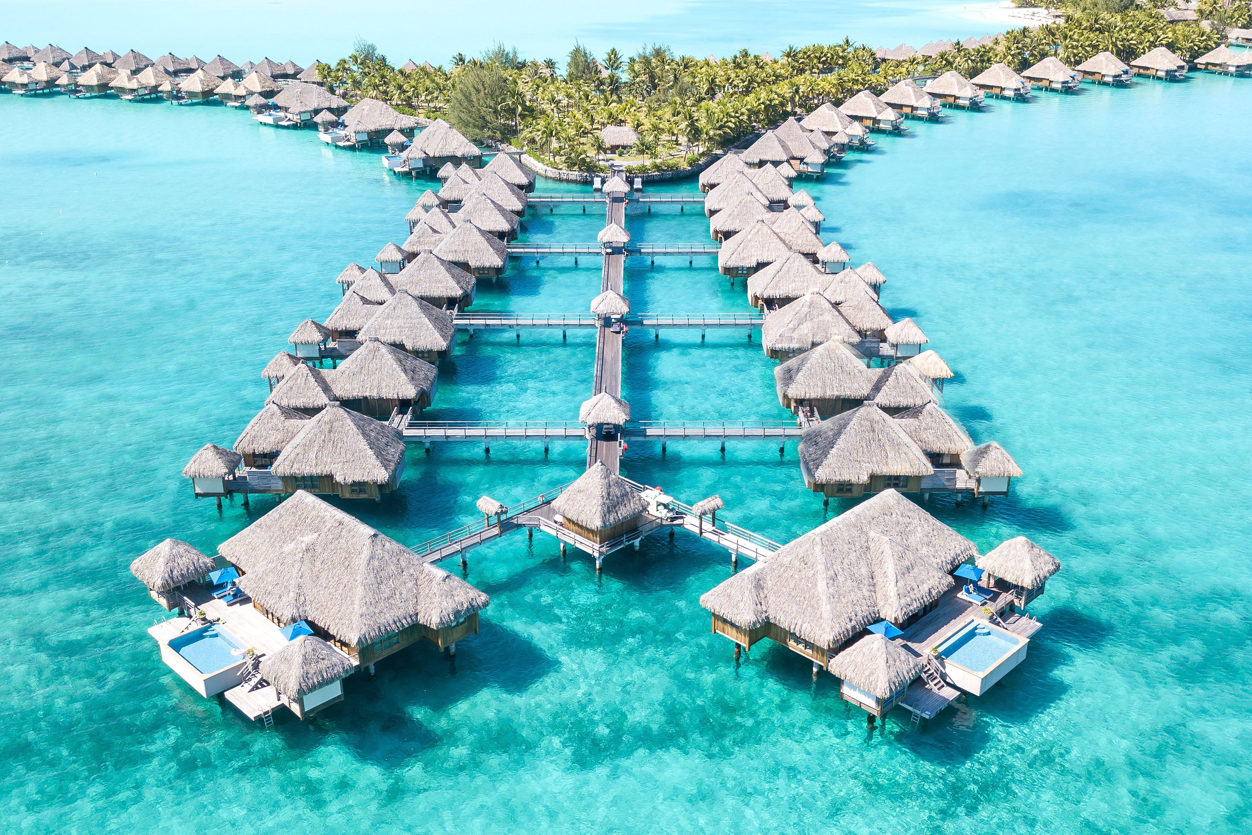 St. Regis Bora Bora Royal Estate overwater suite showing the spacious living area with floor-to-ceiling windows facing the lagoon